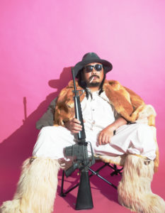 マシンガンを構え座る男