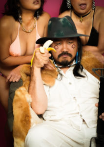 女ふたりに囲まれたマシンガンを持つ男