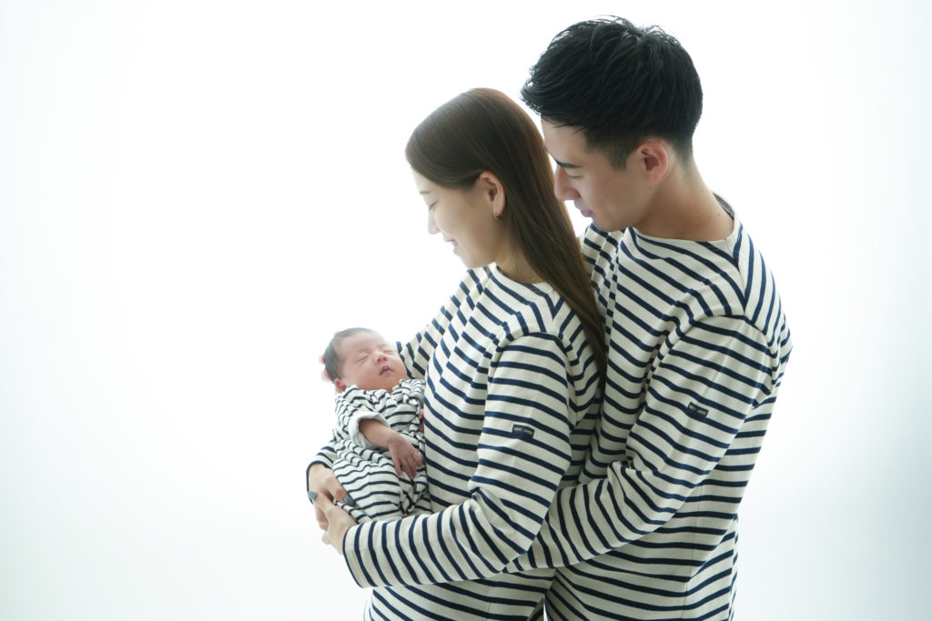 夫婦が赤ちゃんを抱いている写真