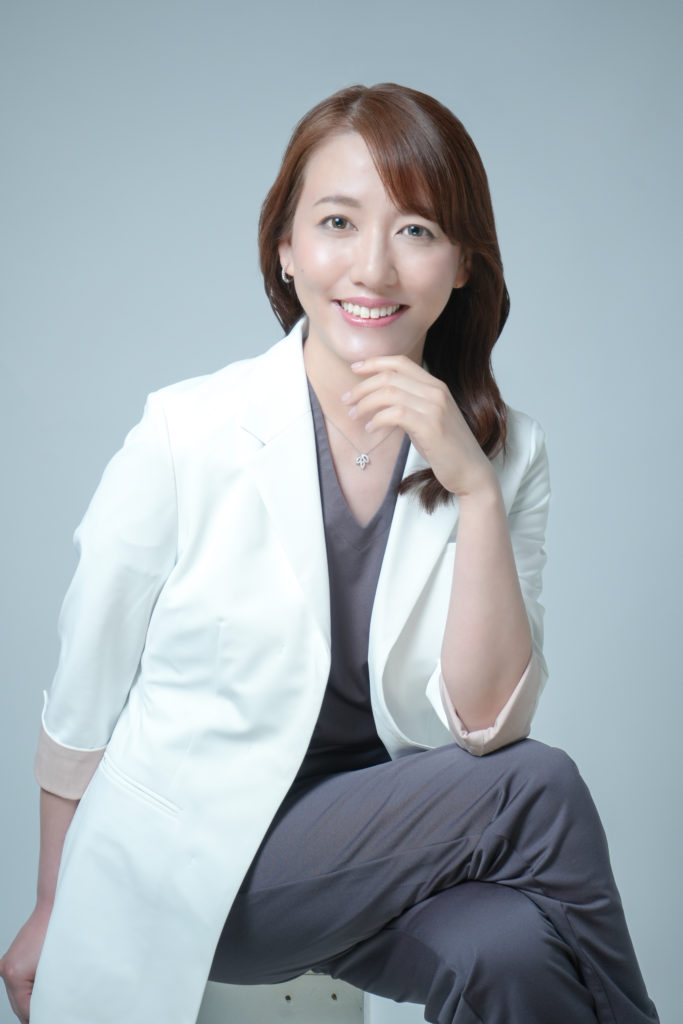 白衣を着た女性ドクターが座っている宣材写真