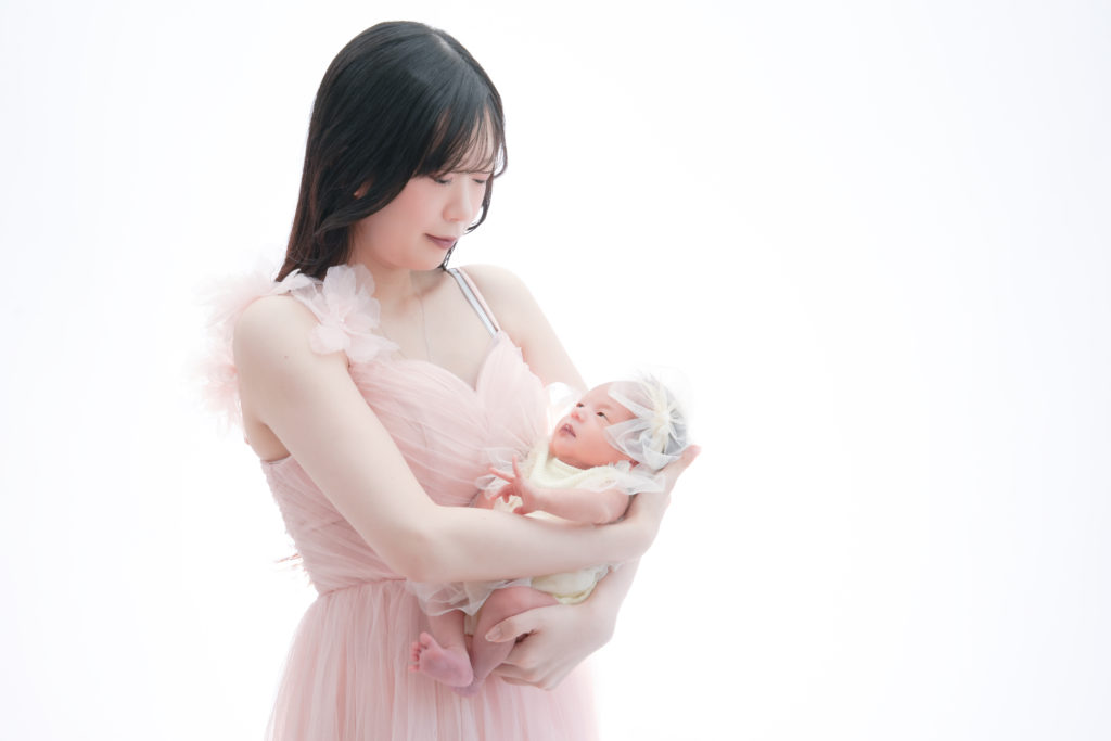 生後２週間の赤ちゃんを抱くお母さんの写真