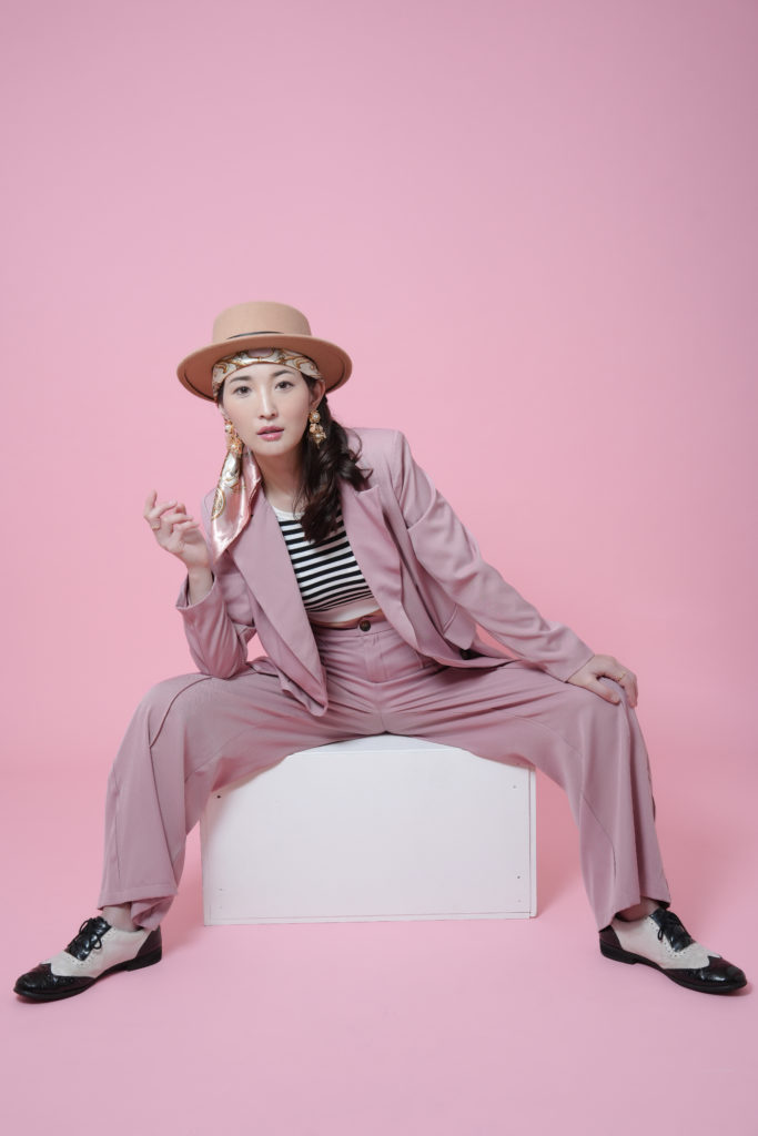 スーツの女性がポーズをとっている