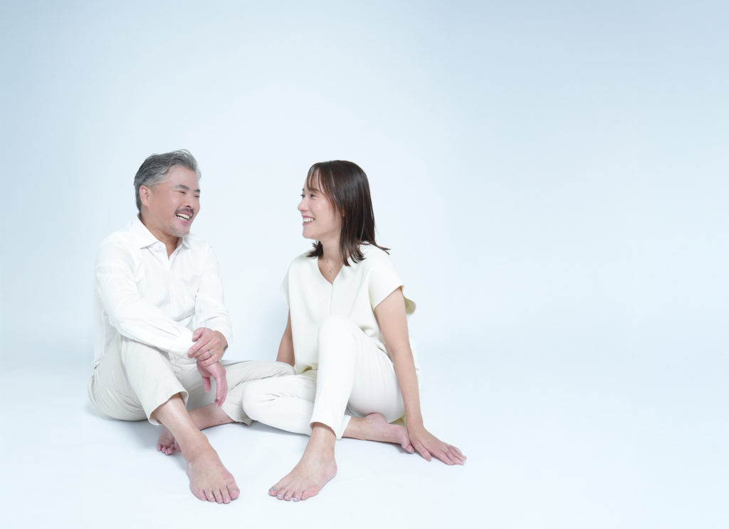 白い服を着た男女が向かい合っている