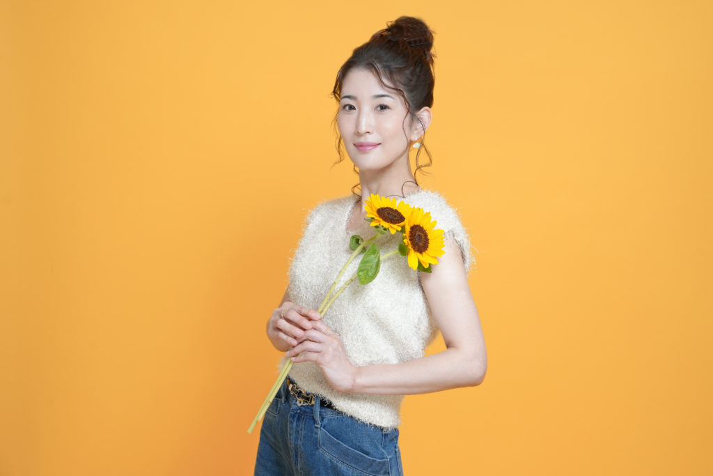 ひまわりを持った女性の写真