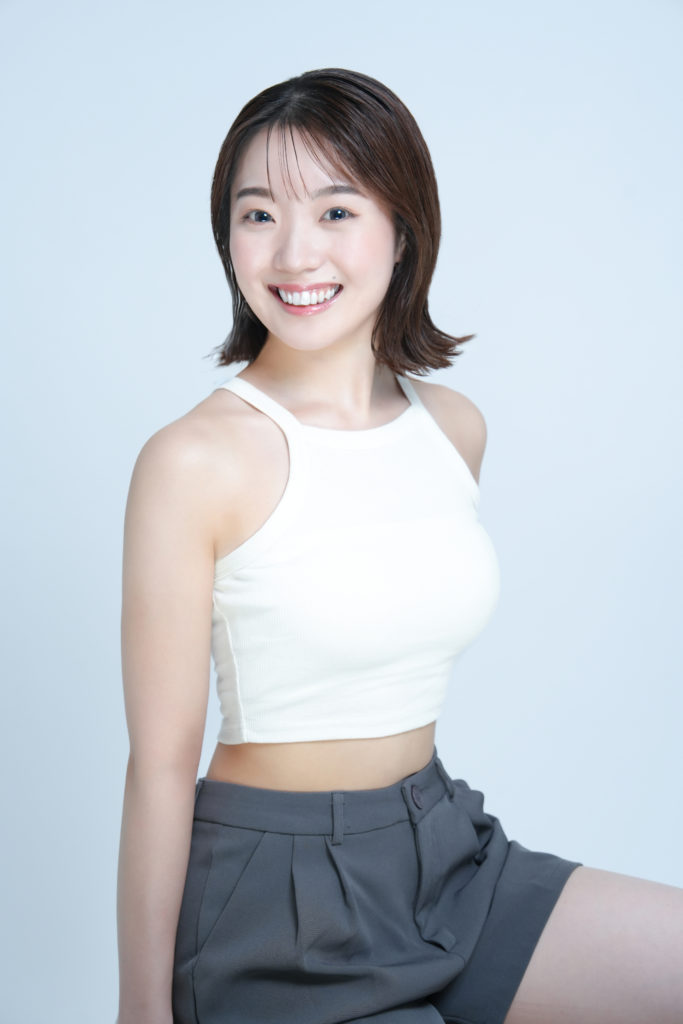 白のタンクトップを着た笑顔の女性