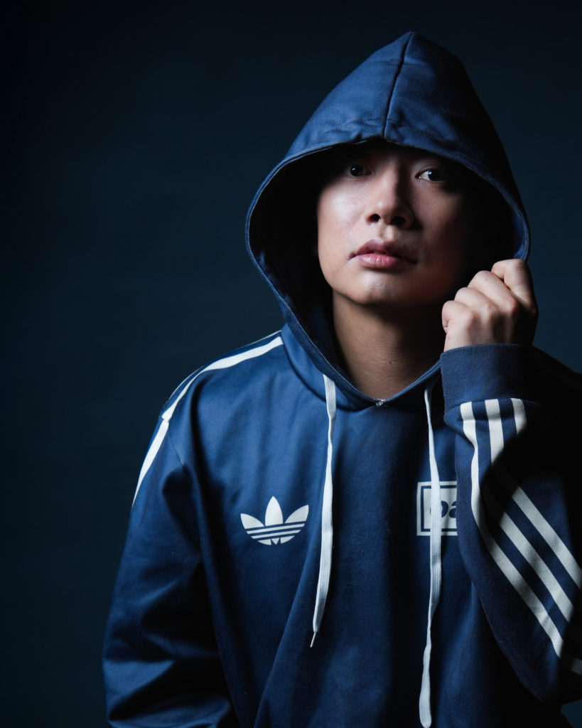 ブルーのパーカーのフードを被った男性の写真