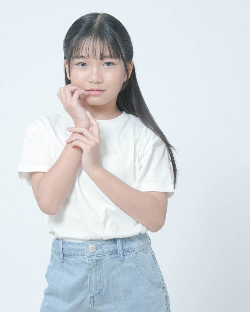 白のTシャツとデニムのスカートを着た女の子の写真