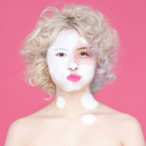 白塗り途中の金髪の女性の写真