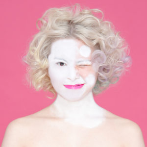 白塗り途中の金髪の女性の写真