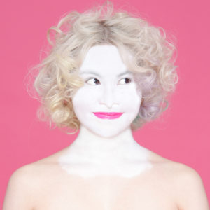 白塗り途中の金髪の女性の写真