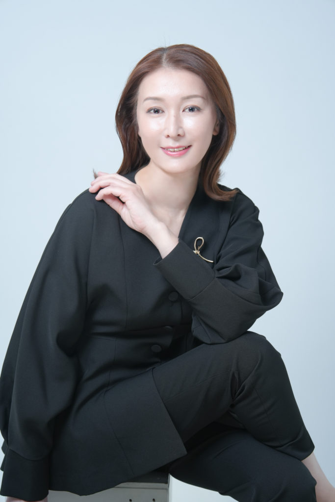 黒の服を着た女性が笑顔の写真