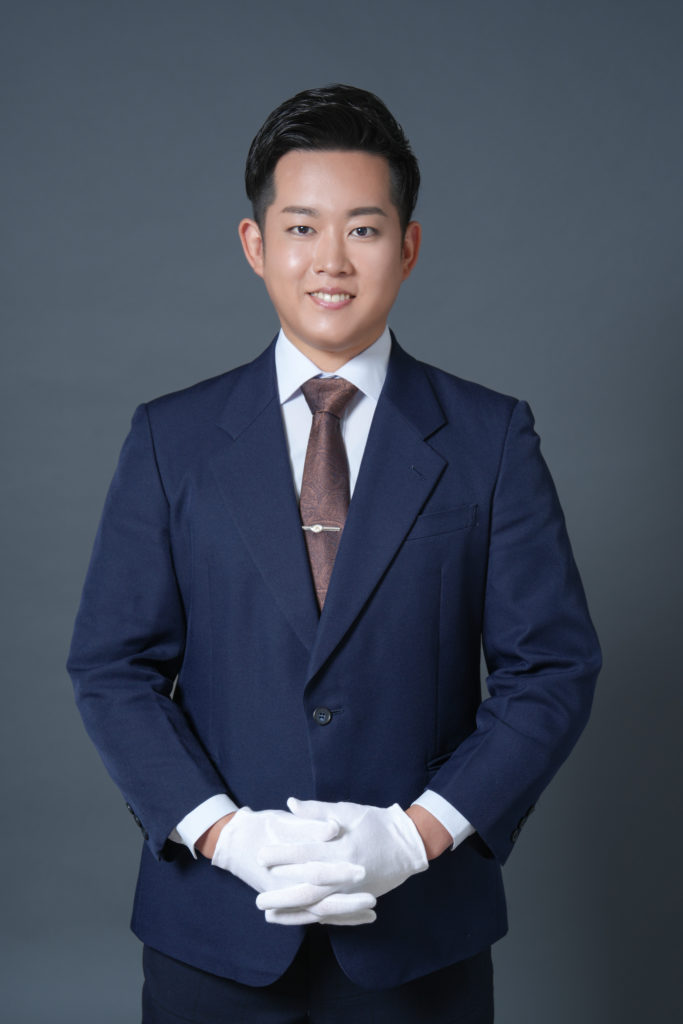 Studio Fictionで撮影した、グレー背景で紺のスーツを着た男性のポートレート写真